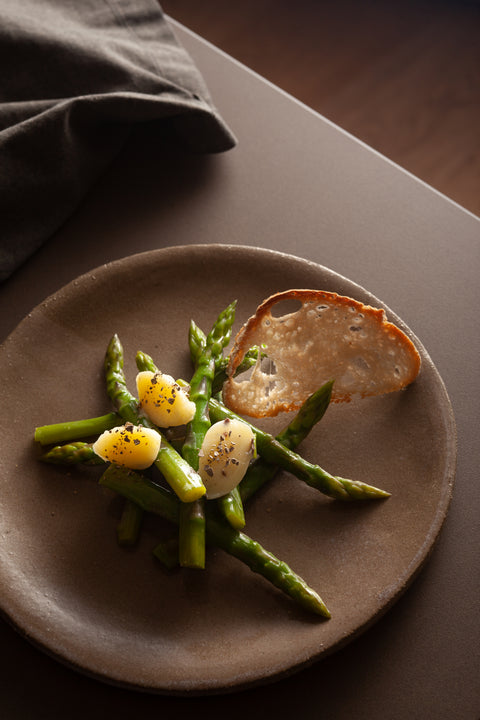 Piatto i Asparagi e patate condite con burro al tartufo bianco e fetta di pane tostato 