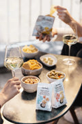 Aperitivo con calici di vino bianco, snack al tartufo Tartuflanghe, olive e frutta secca.